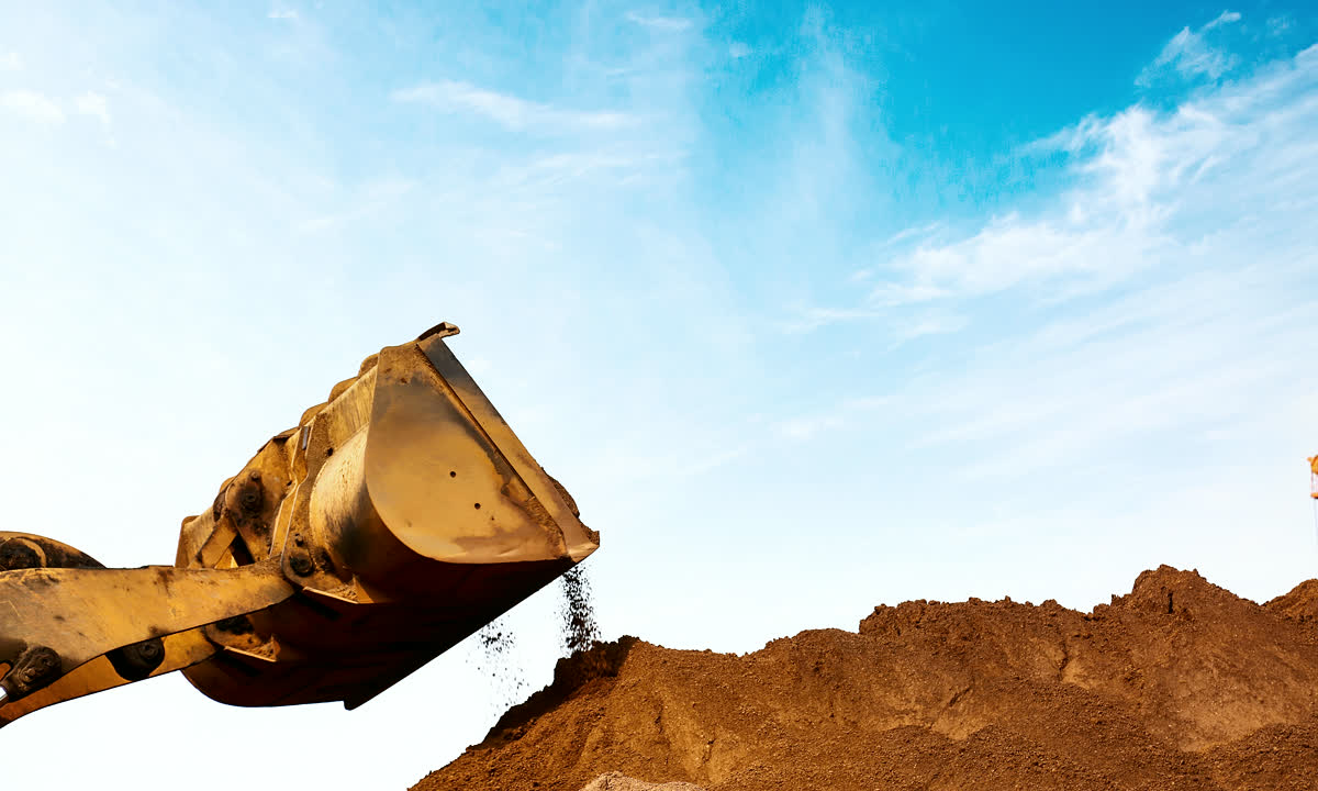 Excavator bucket moving earth on a construction site